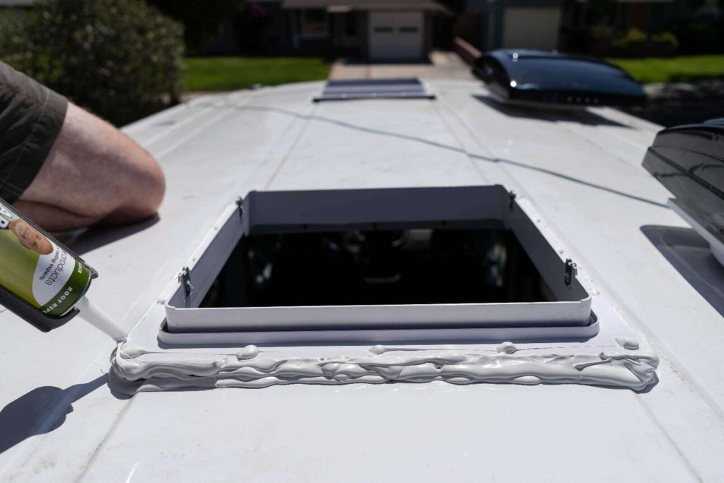 Installing MaxxFan fan in camper van, layering dicor self-leveling sealant on roof