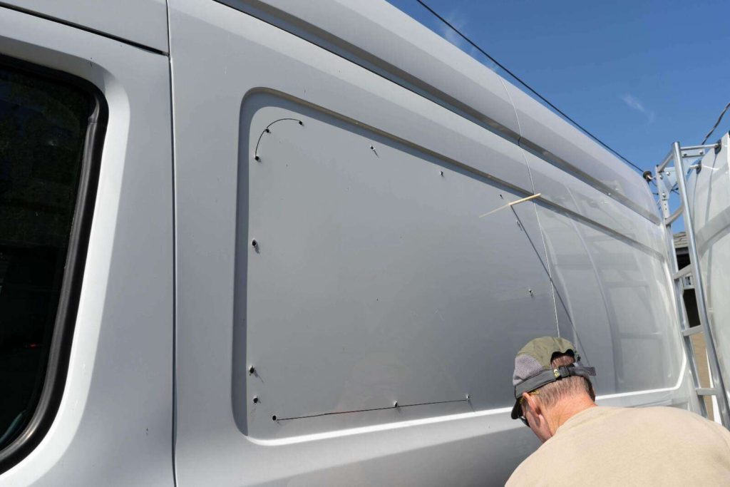 Installing CR Laurence windows on a camper van, drilling helper holes along outline 