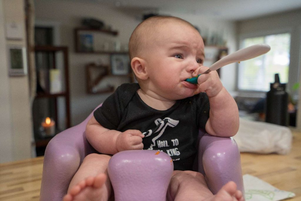 baby feeding himself with spoon